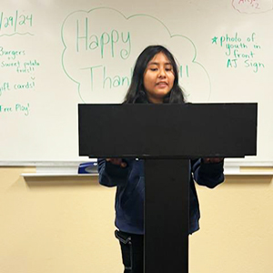 YFJ girl at lectern